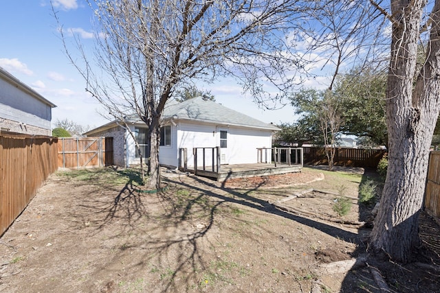 back of property featuring a deck, brick siding, and a fenced backyard