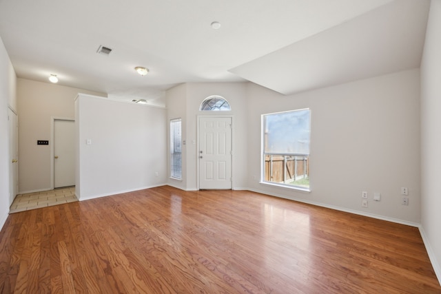 foyer featuring visible vents, baseboards, and wood finished floors