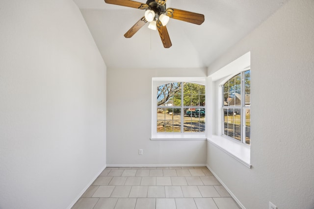 unfurnished room featuring a ceiling fan, baseboards, vaulted ceiling, and a wealth of natural light