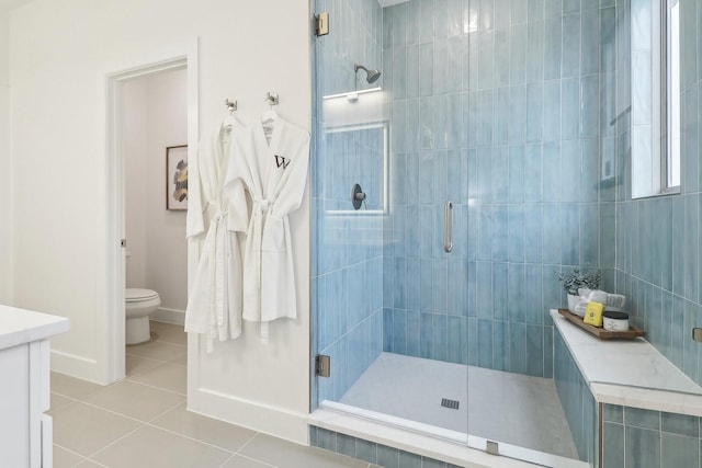 full bath with tile patterned flooring, toilet, vanity, baseboards, and a stall shower