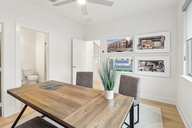 dining area featuring light wood-style floors, baseboards, and a ceiling fan