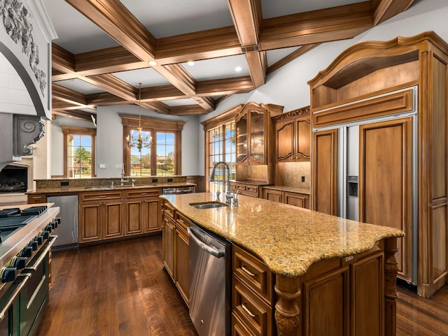 kitchen with brown cabinets, a sink, premium appliances, coffered ceiling, and dark wood-style flooring