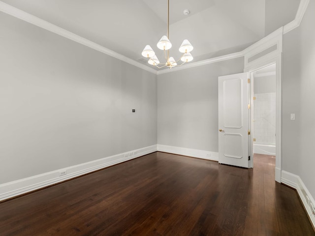 spare room featuring a chandelier, ornamental molding, baseboards, and wood finished floors