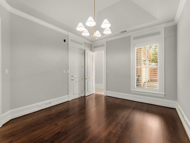 spare room featuring a notable chandelier, visible vents, ornamental molding, and wood finished floors