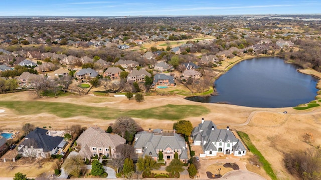 drone / aerial view featuring golf course view, a residential view, and a water view