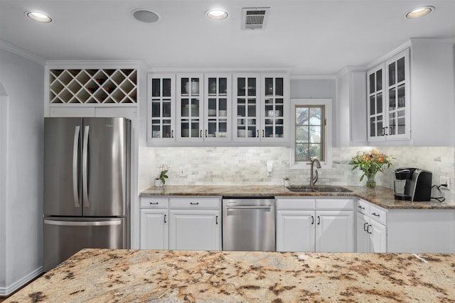 kitchen with stainless steel appliances, a sink, visible vents, and crown molding