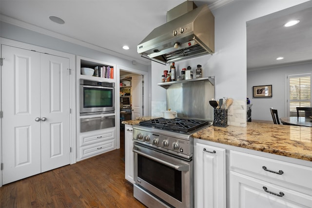 kitchen featuring stainless steel appliances, a warming drawer, wall chimney range hood, and open shelves