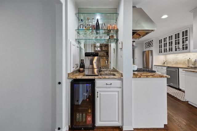 bar with wine cooler, range hood, indoor wet bar, stainless steel appliances, and backsplash