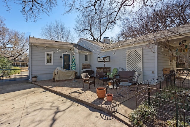 rear view of house with a chimney, a patio area, and fence