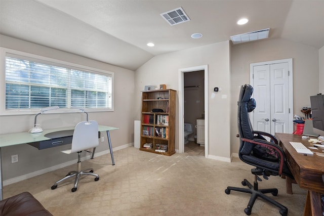 office area featuring lofted ceiling, baseboards, visible vents, and light colored carpet