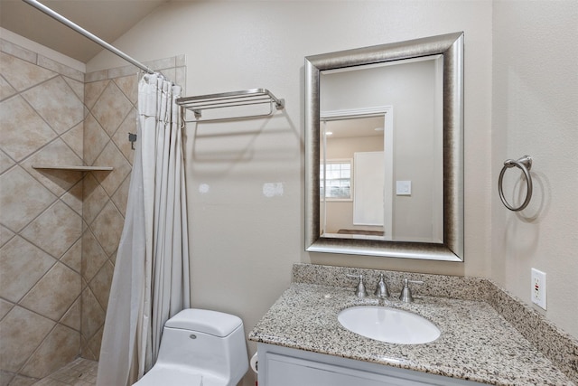 bathroom featuring toilet, tiled shower, vaulted ceiling, and vanity