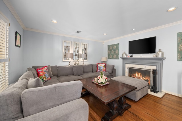 living room featuring recessed lighting, ornamental molding, wood finished floors, and a high end fireplace