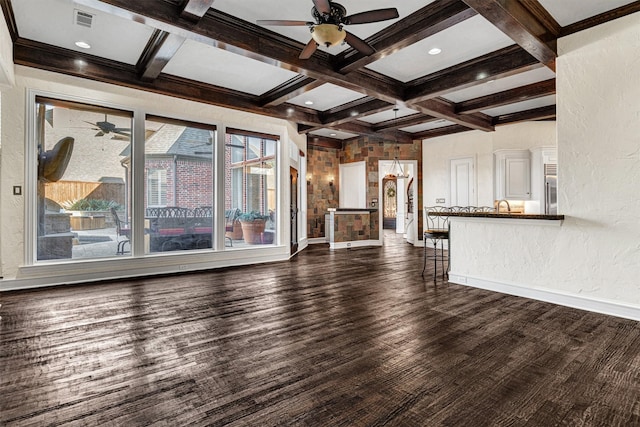 unfurnished living room with dark wood-style flooring, beam ceiling, coffered ceiling, and baseboards