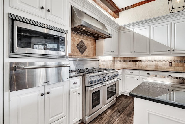 kitchen with wall chimney exhaust hood, appliances with stainless steel finishes, white cabinets, and a warming drawer