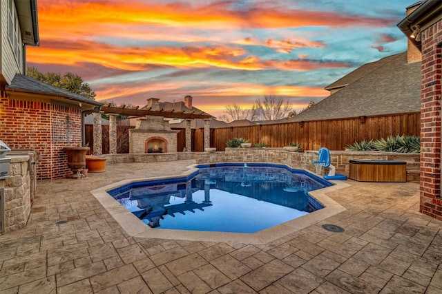 pool at dusk with a fenced backyard, an outdoor stone fireplace, and a patio