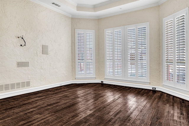 unfurnished room with a wealth of natural light, visible vents, and a textured wall