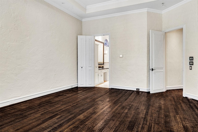 unfurnished room featuring baseboards, a textured wall, wood finished floors, and crown molding