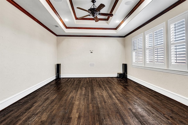 spare room with wood finished floors, a ceiling fan, baseboards, a tray ceiling, and crown molding