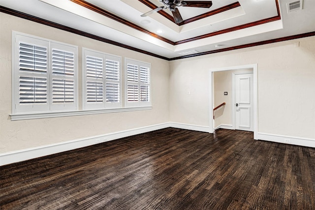 unfurnished room with visible vents, ceiling fan, wood finished floors, a tray ceiling, and crown molding