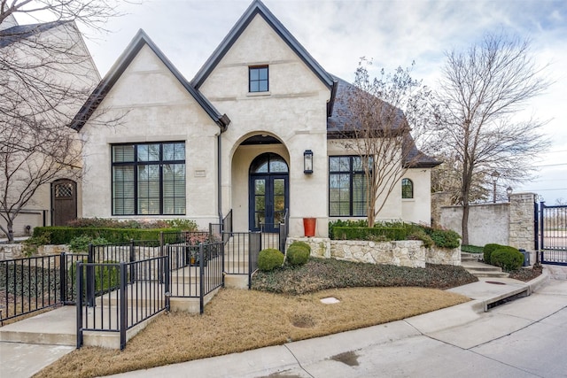 view of front facade with a fenced front yard, a gate, and stucco siding