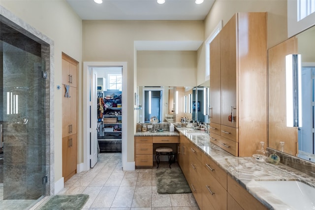 bathroom with a spacious closet, a stall shower, vanity, and recessed lighting