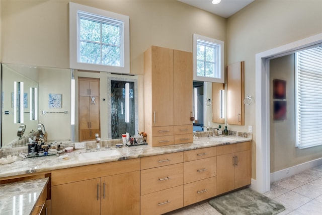 full bath featuring tile patterned flooring, a sink, a high ceiling, and double vanity