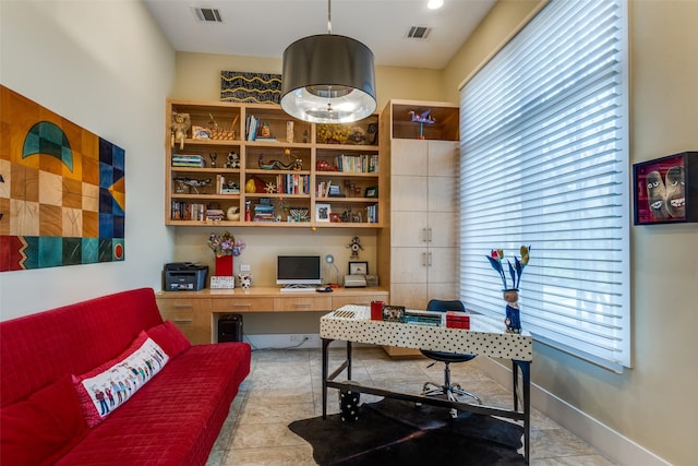 tiled office space with a healthy amount of sunlight, visible vents, and built in desk