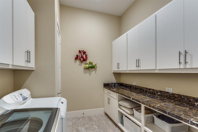 laundry room with cabinet space, baseboards, and washer and dryer