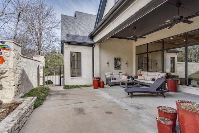 view of patio with a gate, an outdoor hangout area, and a ceiling fan