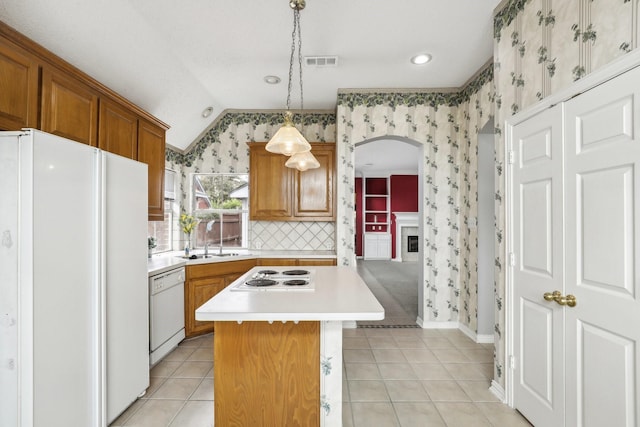 kitchen with white appliances, wallpapered walls, visible vents, and a sink