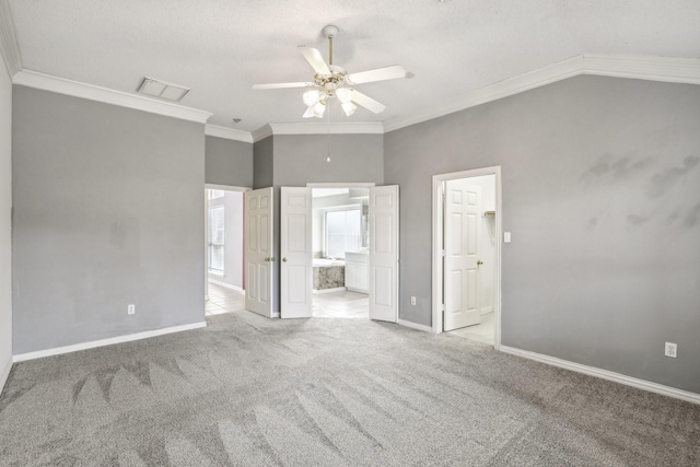 unfurnished bedroom featuring visible vents, baseboards, ensuite bath, crown molding, and carpet flooring