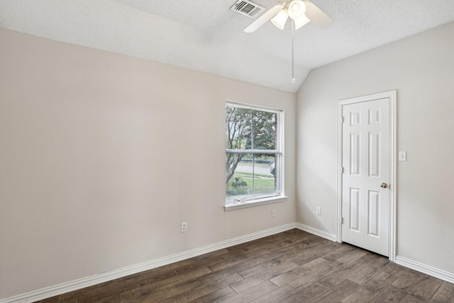 spare room with lofted ceiling, ceiling fan, a textured ceiling, visible vents, and dark wood finished floors