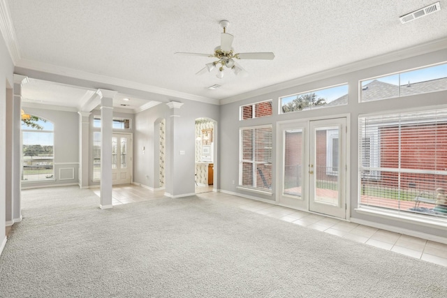 unfurnished sunroom with a ceiling fan, visible vents, and ornate columns