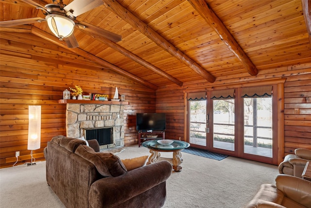 carpeted living area with lofted ceiling with beams, wood ceiling, a ceiling fan, and wood walls