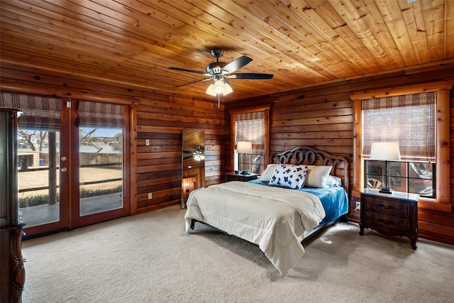 bedroom with ceiling fan, wooden ceiling, wooden walls, access to exterior, and carpet