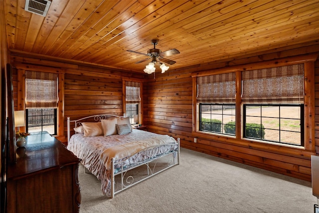 carpeted bedroom with a ceiling fan, wood ceiling, visible vents, and wooden walls