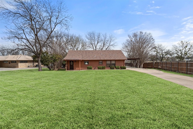 view of front of house with a shingled roof, a front yard, and fence