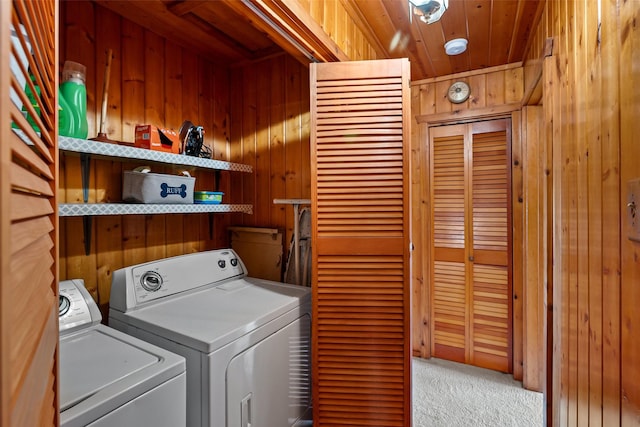 clothes washing area featuring wooden ceiling, carpet, wooden walls, and washing machine and clothes dryer