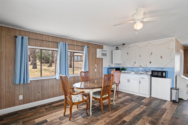 dining room featuring wooden walls, baseboards, ceiling fan, dark wood-style flooring, and an AC wall unit