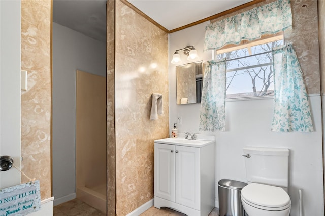 bathroom with toilet, vanity, baseboards, walk in shower, and crown molding