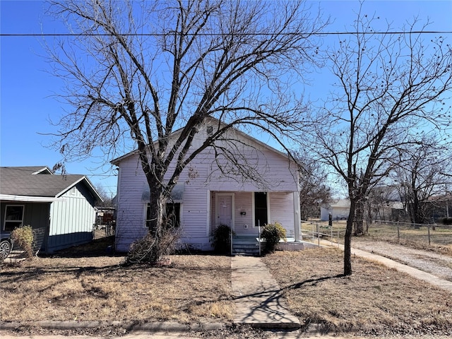 bungalow-style home with a porch and fence