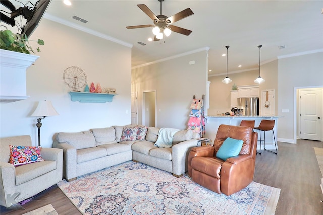 living area with crown molding, visible vents, and dark wood finished floors