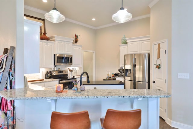 kitchen featuring a breakfast bar, white cabinetry, ornamental molding, and stainless steel appliances