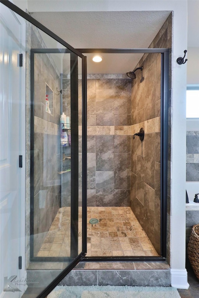 full bath featuring a stall shower and a textured ceiling