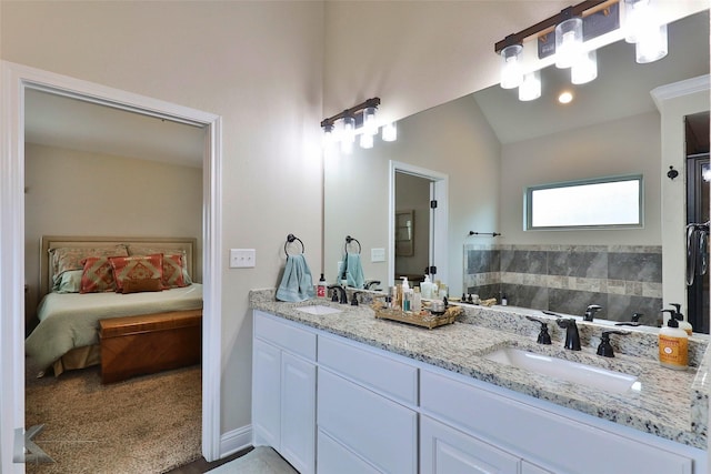 ensuite bathroom featuring vaulted ceiling, double vanity, ensuite bath, and a sink