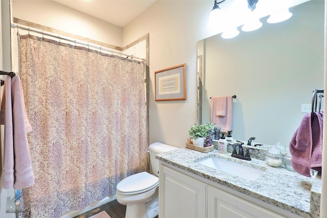 bathroom with toilet, a shower with shower curtain, and vanity