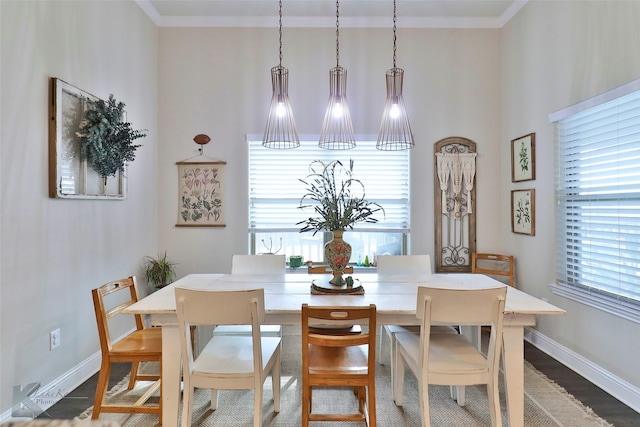 dining area with baseboards, crown molding, and wood finished floors