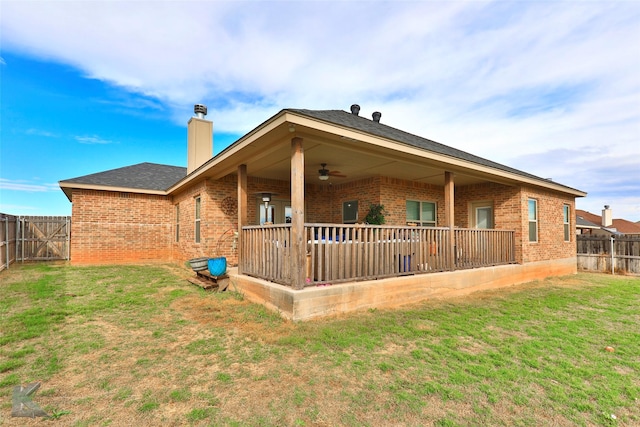 back of house with brick siding, a chimney, a lawn, a patio area, and a fenced backyard