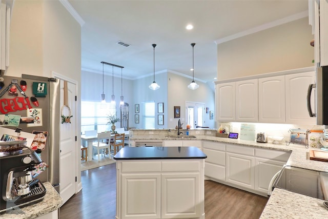 kitchen with a peninsula, visible vents, a sink, and wood finished floors