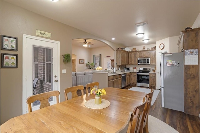 dining room with arched walkways, ceiling fan, recessed lighting, visible vents, and dark wood-style floors